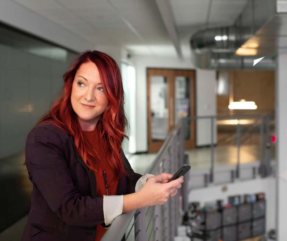A woman smiles as she uses mobile banking