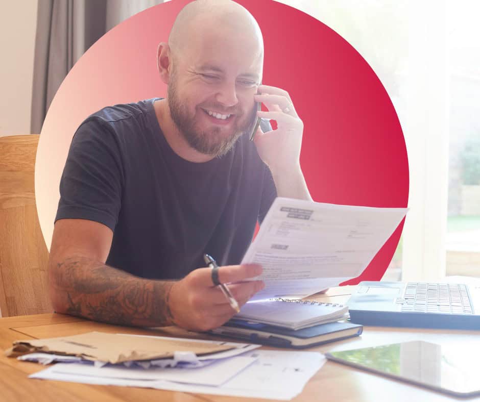 A man talks through some of his home debts with someone on the phone.