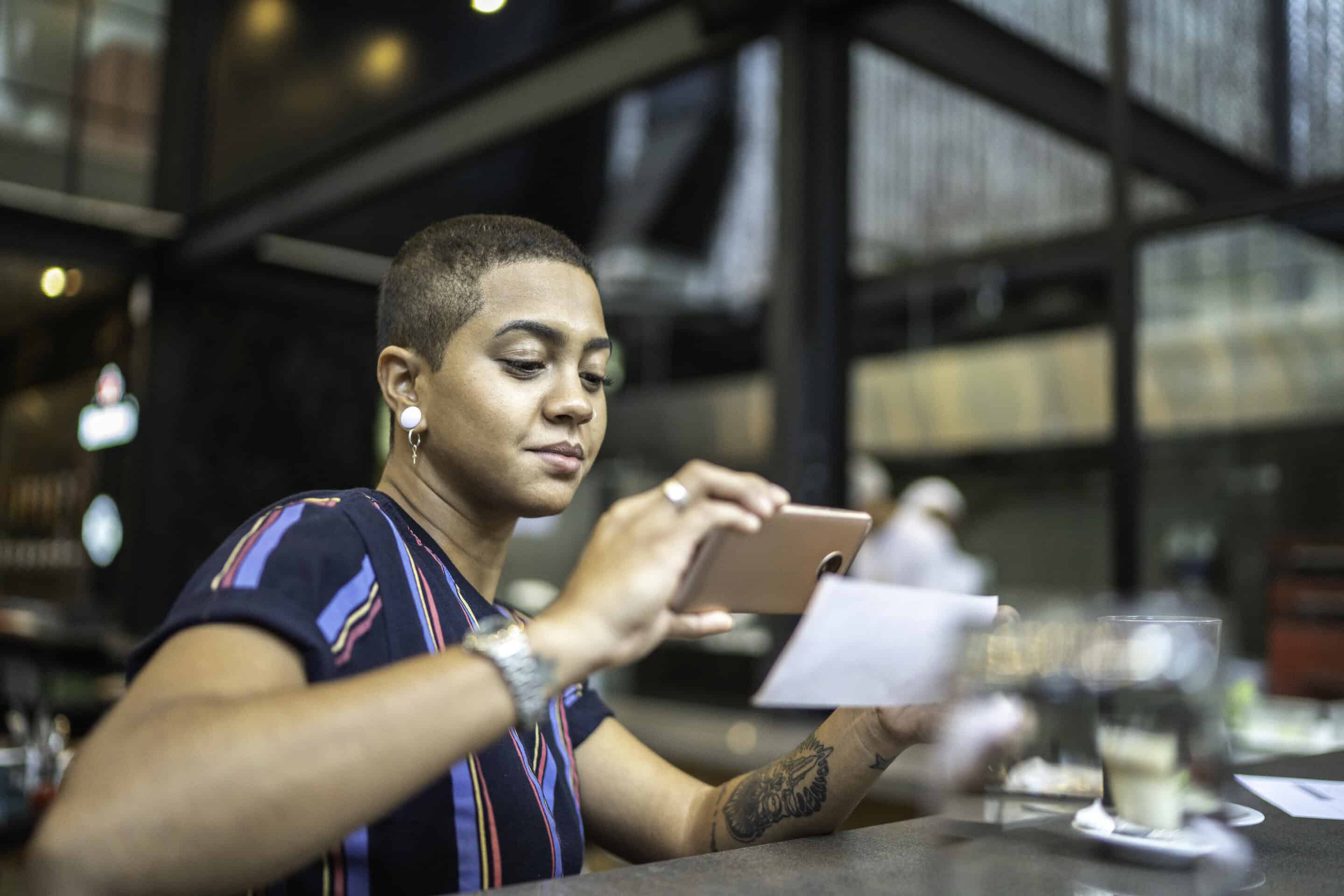 A young woman uses her banking mobile app to deposite a check.