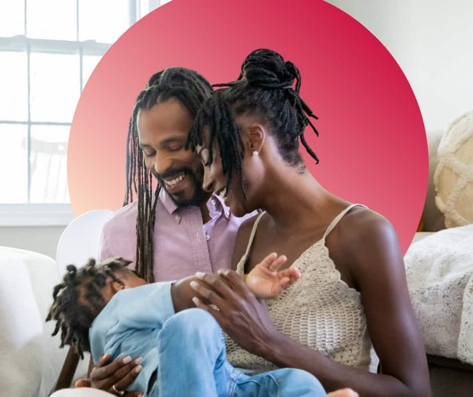 A young Black couple dote on their toddler.
