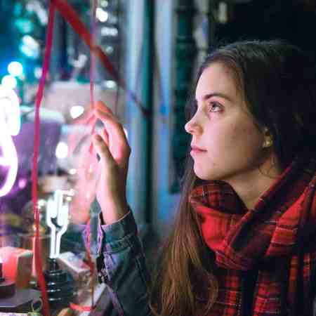A young woman, window shopping during the holidays