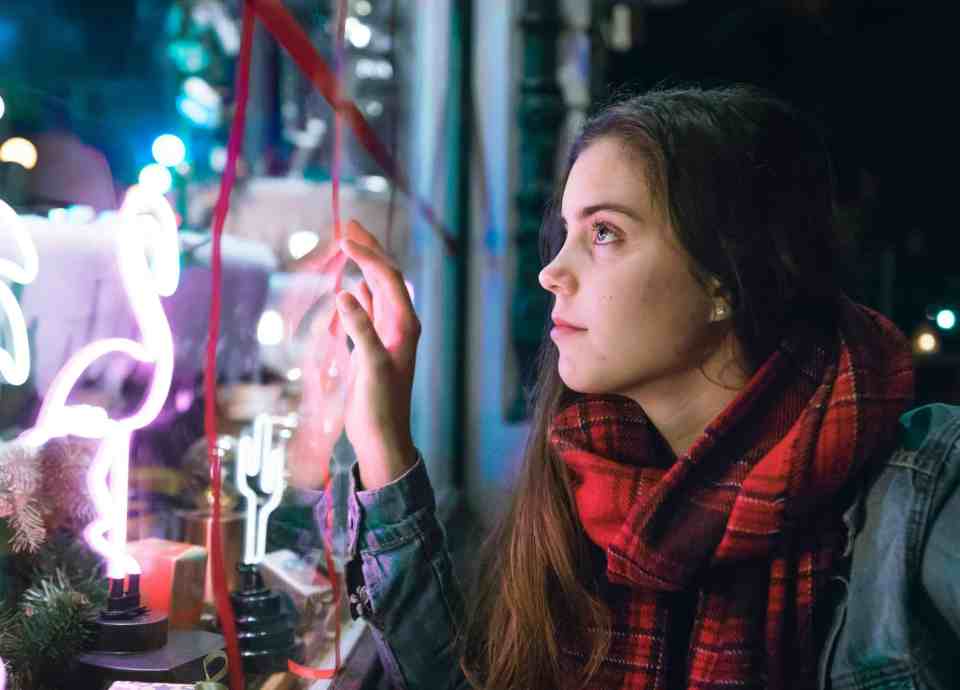 A young woman, window shopping during the holidays