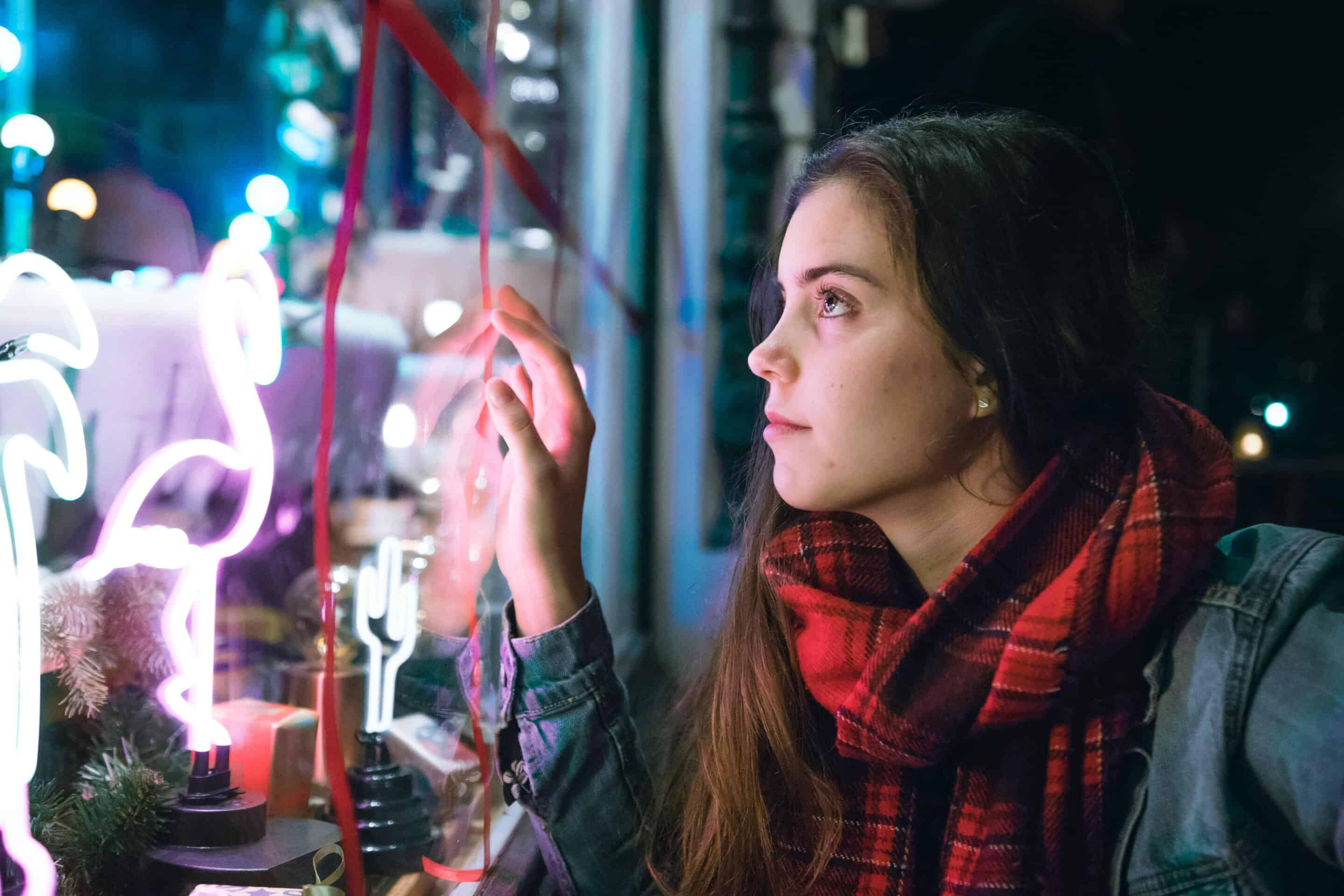 A young woman, window shopping during the holidays