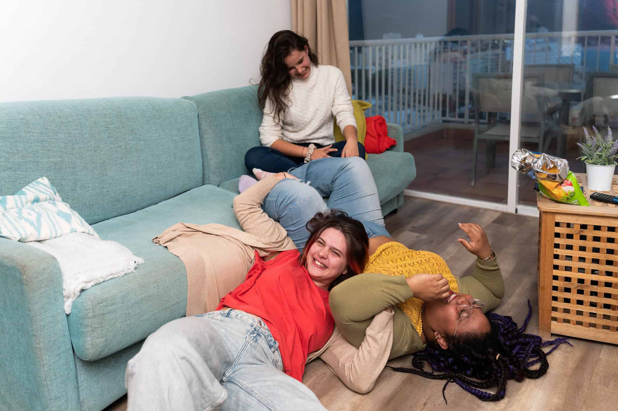 Three young women laughing in student accomodation.