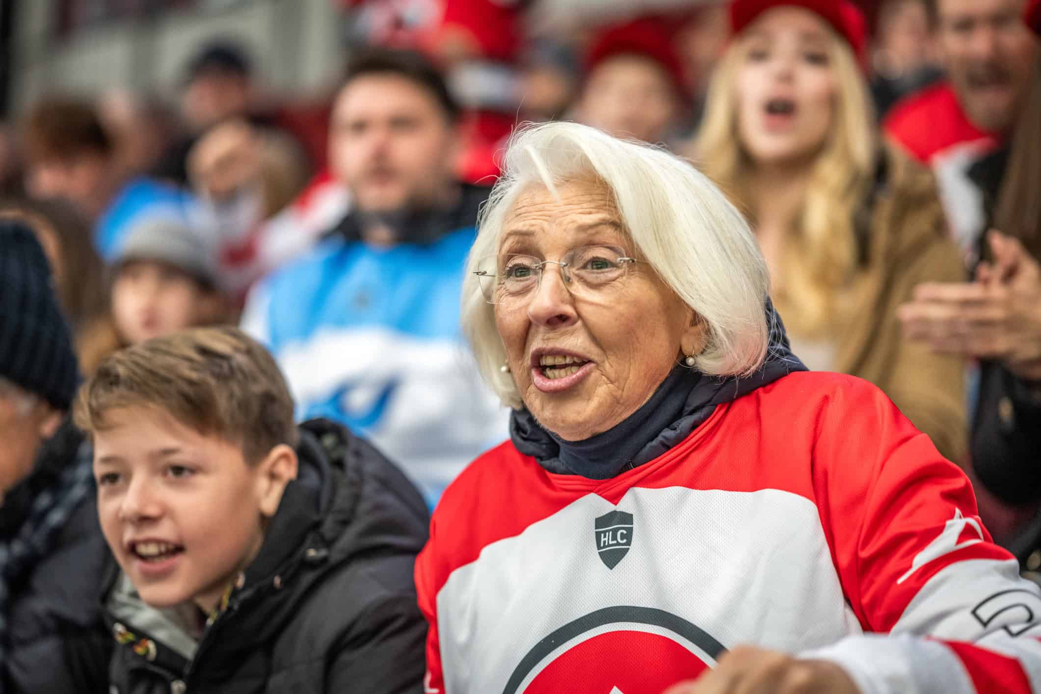 A grandmother and her grandson at an ice hockey game.