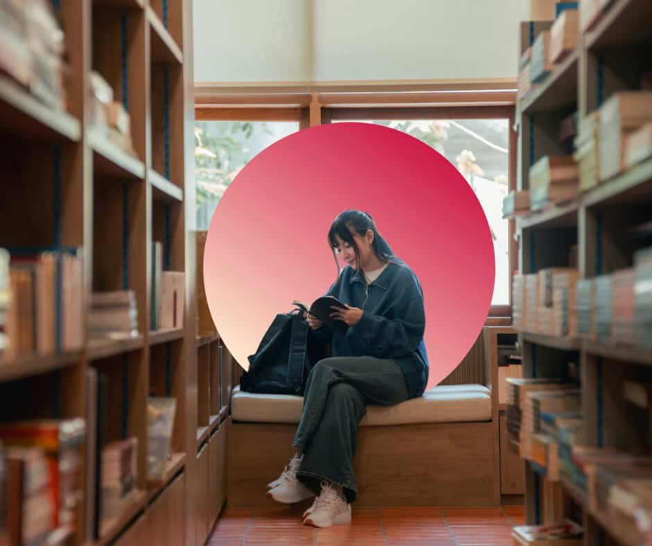 A student sits alone in a college library.