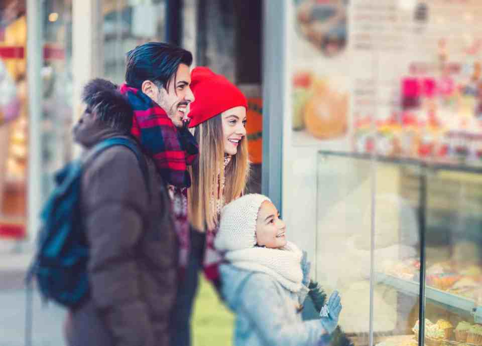 A young family window shopping during the holidays
