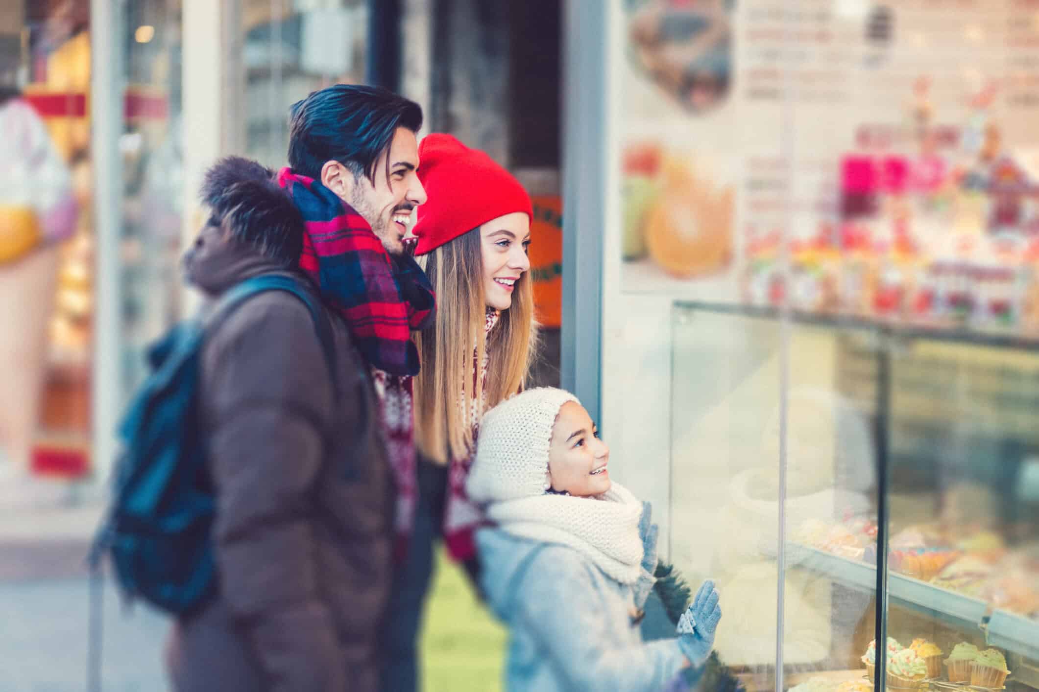 A young family window shopping during the holidays
